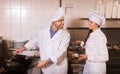 Chef and his helper at bistro kitchen Royalty Free Stock Photo